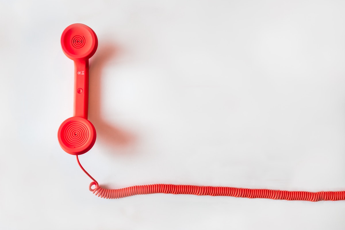A photograph of a red telephone on a white background by Negative Space via Pexels